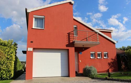 a red house with a white garage door at Family Dream Dalmatia - Split by Villas Guide in Košute