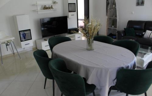 a dining room with a table and green chairs at Family Dream Dalmatia - Split by Villas Guide in Košute