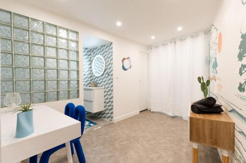 a dining room with a white table and blue chairs at La Cabane du Surfeur in Clermont-Ferrand