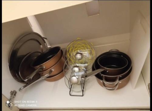 a kitchen counter with pots and pans on a shelf at Apartman Boni in Mali Beograd