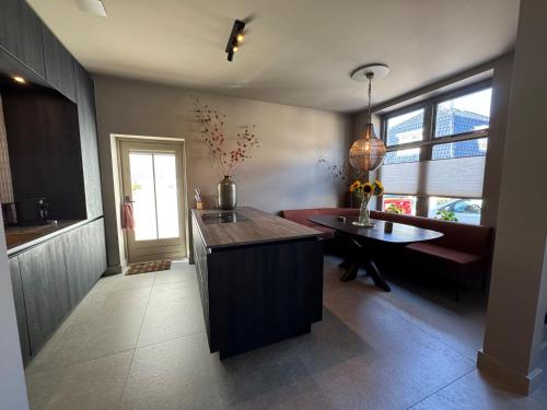 a kitchen with a counter and a table in a room at 't Voorhuys Noordwijk aan Zee- tuin en gratis parkeren in Noordwijk