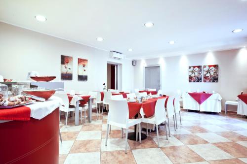 a restaurant with red and white tables and chairs at Hotel San Martino in Cassibile