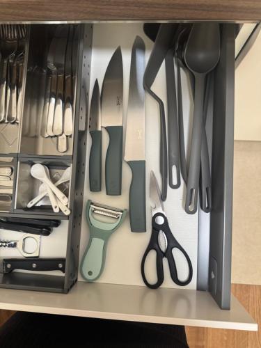 a drawer filled with knives and other kitchen utensils at Lux apartment airport in Ledine