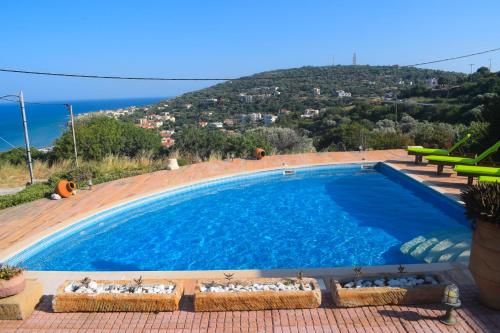 a large swimming pool with a view of the ocean at Tethys Apartments Karfas in Chios