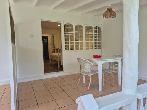 a dining room with a white table and chairs at Beau Vallon Bungalows in Beau Vallon