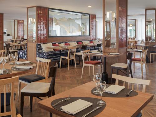 a dining room with wooden tables and chairs at H10 Casa del Mar in Santa Ponsa