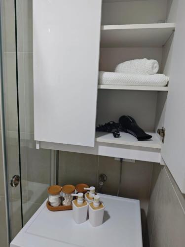 a cupboard in a bathroom with some cups on a shelf at Lux apartment airport in Ledine