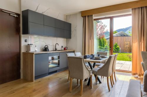 a kitchen and dining room with a table and chairs at Tatra Resort & SPA in Kościelisko