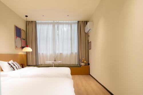 a hotel room with two beds and a window at Xiamen Evening Breeze Hotel in Xiamen