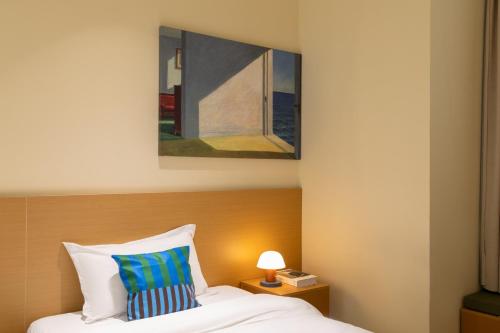 a bedroom with a bed with a painting on the wall at Xiamen Evening Breeze Hotel in Xiamen