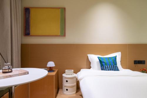 a hotel room with a bed and a sink at Xiamen Evening Breeze Hotel in Xiamen