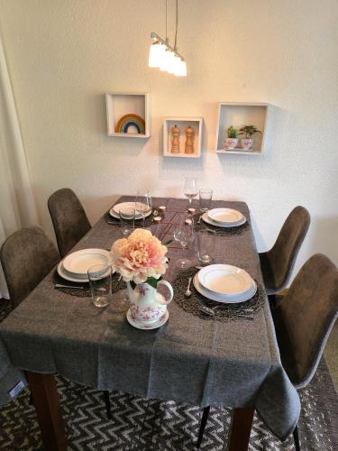 a table with plates and glasses and a vase with flowers at Ferienwohnung Kassler - nur 300m vom See in Schwarzsee