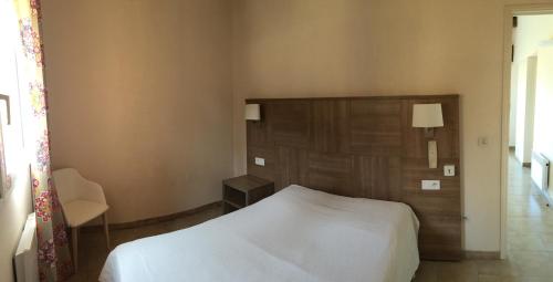 アルガジョラにあるRésidence Beau rivageのベッドルーム(白いベッド1台、木製ヘッドボード付)
