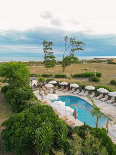 an aerial view of a resort pool with umbrellas and chairs at CAPAO Beach Hôtel in Cap d'Agde