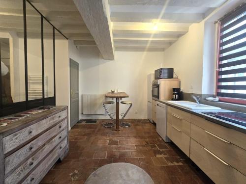 eine Küche mit einer Theke und einem Tisch darin in der Unterkunft le rêve suspendu in Le Mans