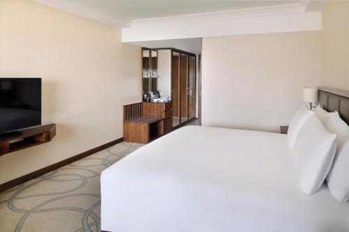 a hotel room with a bed and a flat screen tv at InterContinental Bahrain by IHG in Manama