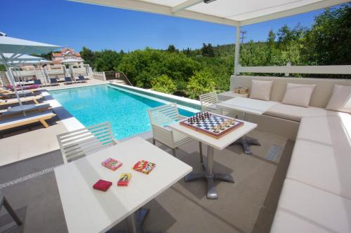 a pool with a table and chairs and a chess board at Magnolia Apartments in Fiskardho