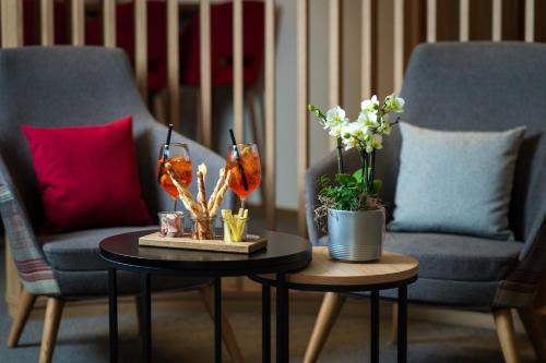 a living room with two chairs and a table with flowers at Randolins Familienresort in St. Moritz