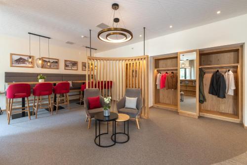 a dressing room with red chairs and a table at Randolins Familienresort in St. Moritz