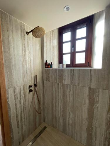 a bathroom with a shower and a window at The Red Cliffs Villa in Leonidio
