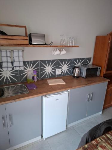 a kitchen with white cabinets and a counter top at Fig Tree in Colesberg