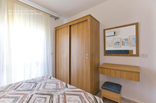 a bedroom with a bed and a wooden cabinet at Mountain View Luxury Garden Chalet - North Coast in Ras Elhekma