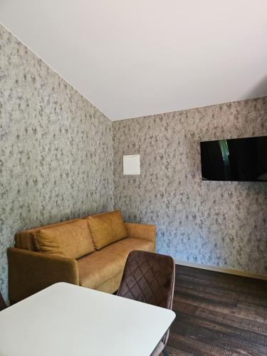 a living room with a couch and a flat screen tv at Hotel resort Sedula in Skogalis