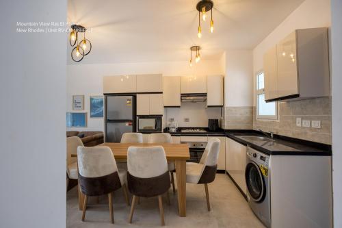 a kitchen and dining room with a table and chairs at Mountain View Luxury Garden Chalet - North Coast in Ras Elhekma