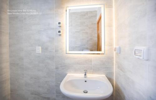 a bathroom with a sink and a mirror at Mountain View Luxury Garden Chalet - North Coast in Ras Elhekma