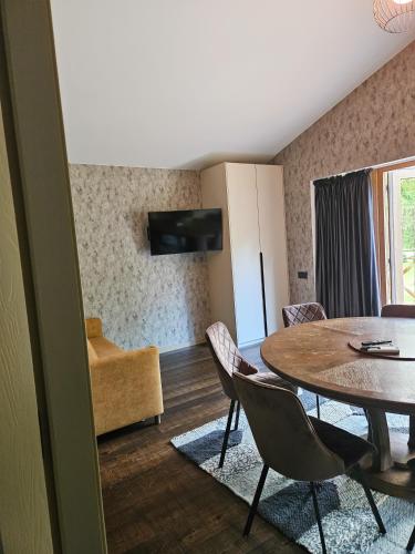 a living room with a dining room table and chairs at Hotel resort Sedula in Skogalis