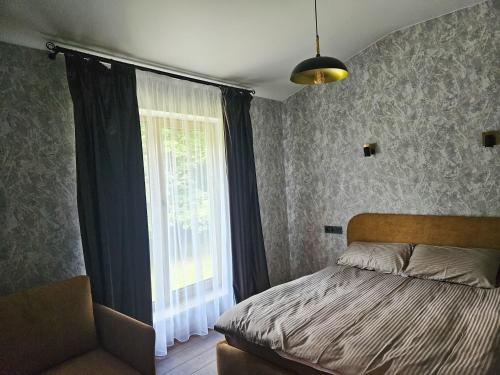 a bedroom with a bed and a large window at Hotel resort Sedula in Skogalis