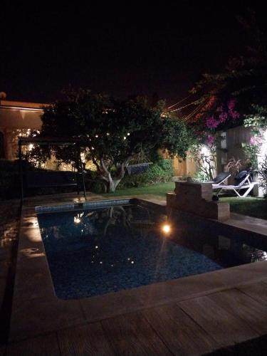a swimming pool in a yard at night at maison les jasmins in Tazarka