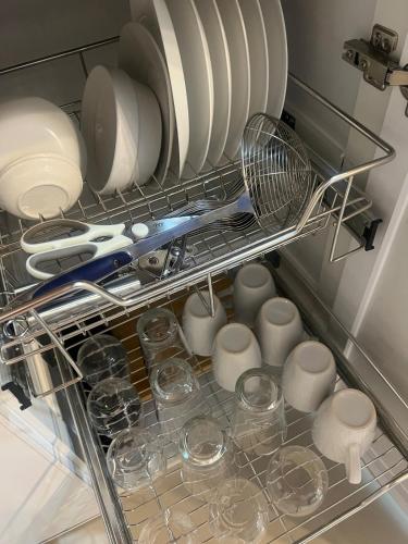 a drawer filled with dishes and plates and a strainer at Skyview 2BR at Grass in Manila