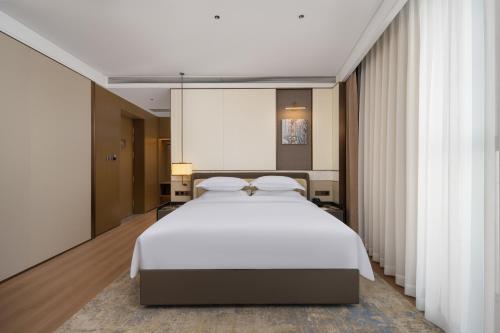 Кровать или кровати в номере Wyndham Garden Urumqi Innovation Square