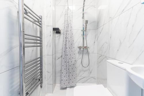 ein weißes Badezimmer mit einer Dusche mit Krawatte in der Unterkunft NEW Contractors House 6 Bedrooms Parking 10 Guests in Romford