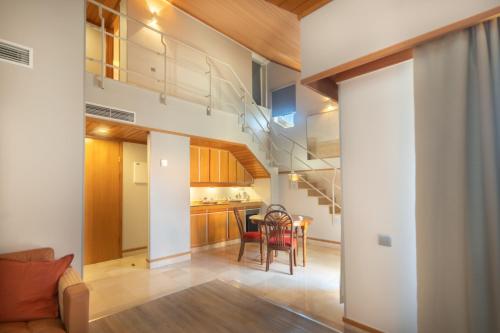 a living room and kitchen with a staircase in a house at Hotel Solar Palmeiras in Paço de Arcos