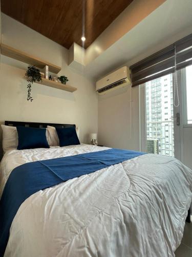 a bedroom with a large bed with a large window at Skyview 2BR at Grass in Manila