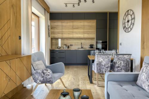 a kitchen and living room with a couch and a table at Tatra Resort & SPA in Kościelisko