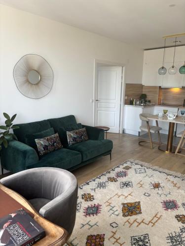 a living room with a green couch and a kitchen at Cocoon Retreat in Chantilly
