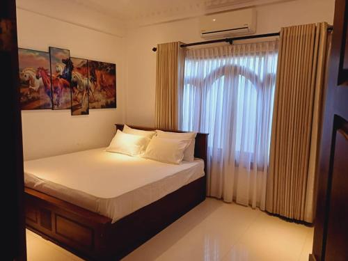 a small bedroom with a bed and a window at JarushanInnHotel in Jaffna