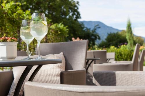 two glasses of white wine sitting on an outdoor table at Hotel Stefanshof in Plaus