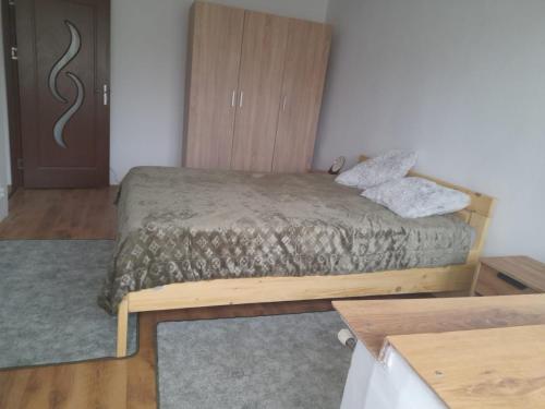 a bedroom with a bed and a wooden cabinet at Denis House in Zalău
