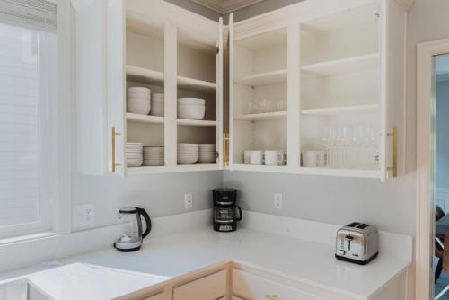 una cucina con mobili bianchi e stoviglie bianche di Blueground Issaquah balcony wd parking SEA-759 a Seattle