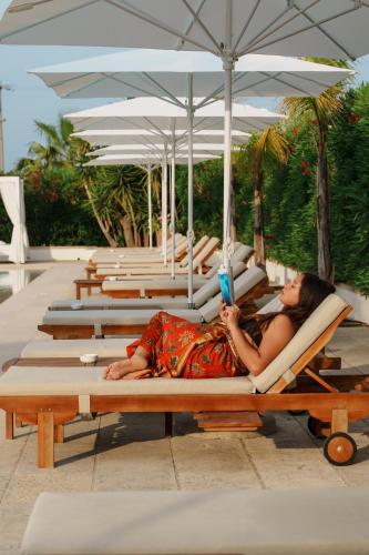 a woman laying on a lounge chair on the beach at Tenuta Centoporte in Otranto