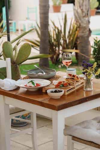 a table with plates of food and a glass of wine at Tenuta Centoporte in Otranto