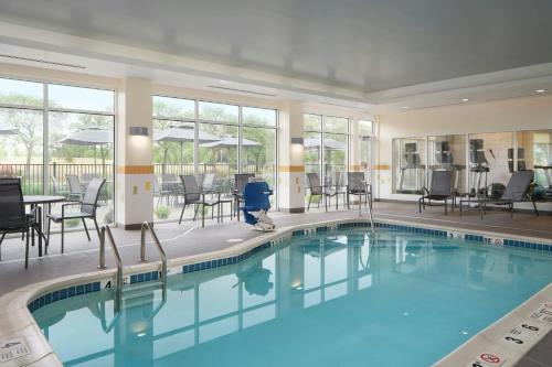 a pool in a hotel with chairs and tables at Fairfield by Marriott Niagara Falls in Niagara Falls