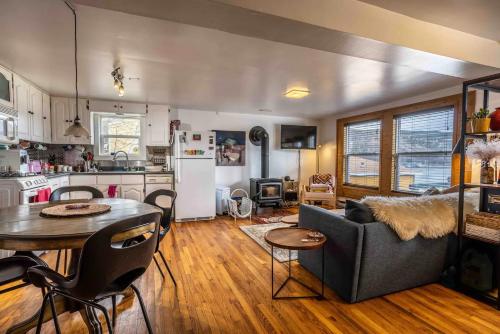 a kitchen and living room with a couch and a table at Iconic Battery Cottage Signal Hill Sea&City Views in St. John's
