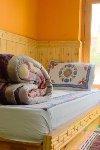 a bedroom with a bed with a blanket and a pillow at SpitiTara Homestay in Kaza