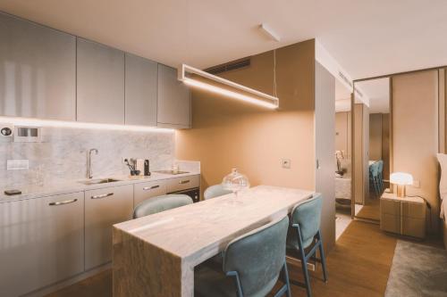 a kitchen with a large marble table and blue chairs at Viterbo'8 - Bonjardim Apartments in Porto