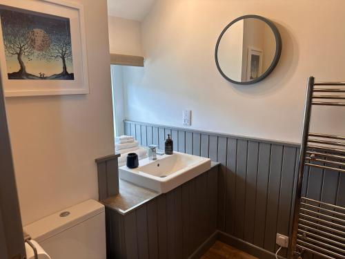 ein Badezimmer mit Waschbecken und Spiegel in der Unterkunft Charming cosy cottage near the Lake District in Penrith